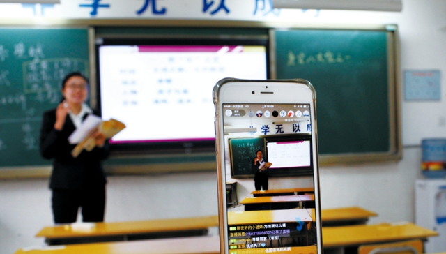 西安市第26中学的老师19日通过手机直播向学生教授语文课程